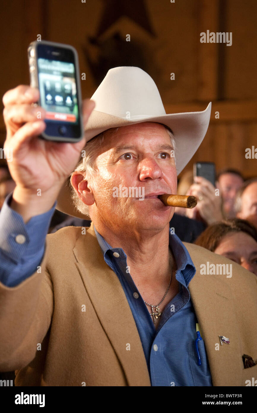 Mann in Cowboy-Hut nutzt sein IPhone aufnehmen texanischen Gouverneur Rick Perry spricht nach seiner Wiederwahl Sieg am 2. November Stockfoto