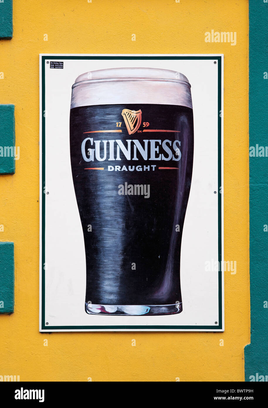 Guinness-Schild an der kleinen Brücke Pub Wand, Dingle, County Kerry, Munster, Irland. Zeichen von Mc Closkey Zeichen. Stockfoto