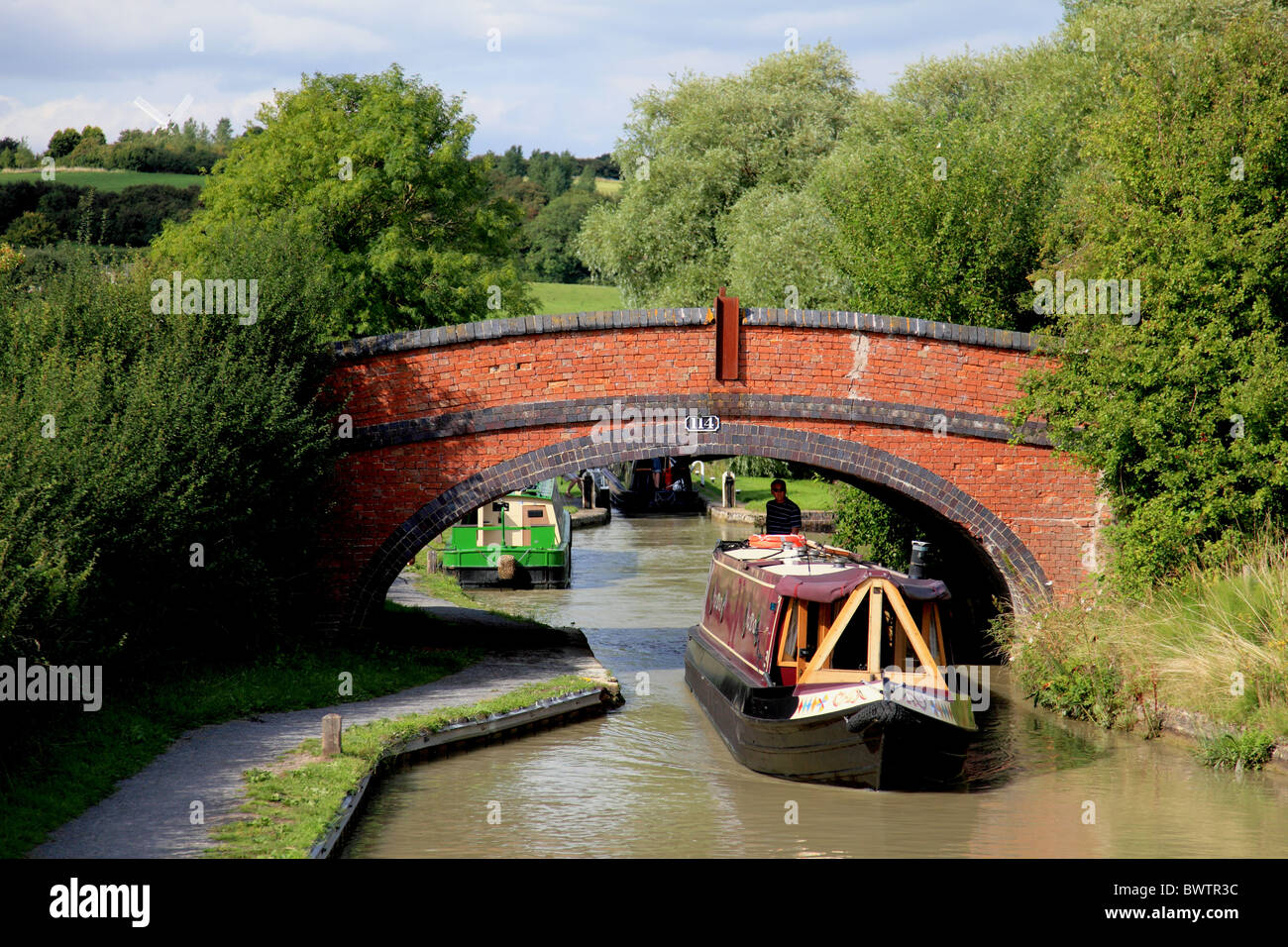 Narrowboat gehen unter der Brücke 114 am Oxford-Kanal bei Napton-on-the-Hill Stockfoto