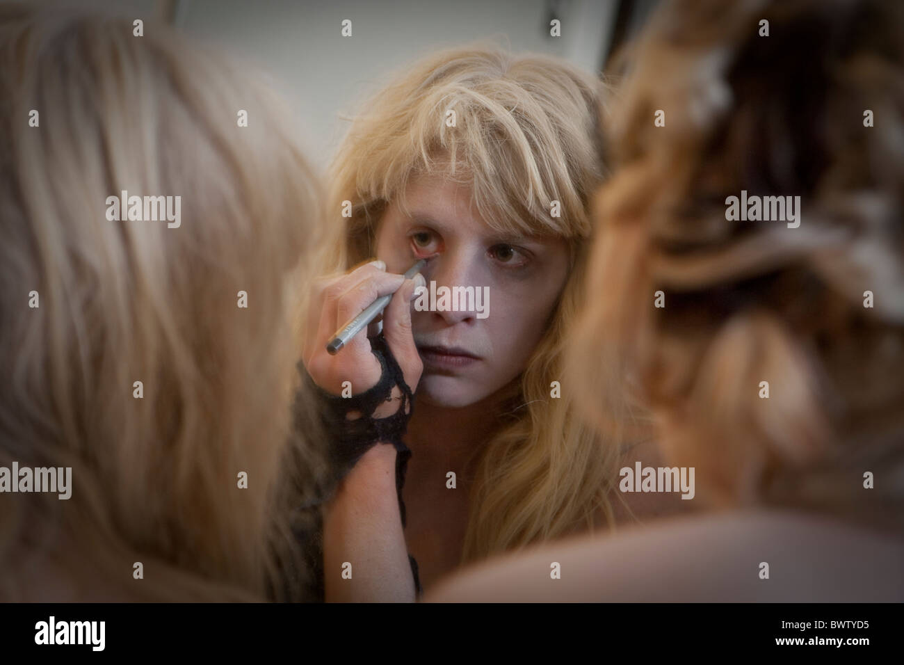 Zombie-Mädchen tut Halloween Make-up im Spiegel Stockfoto