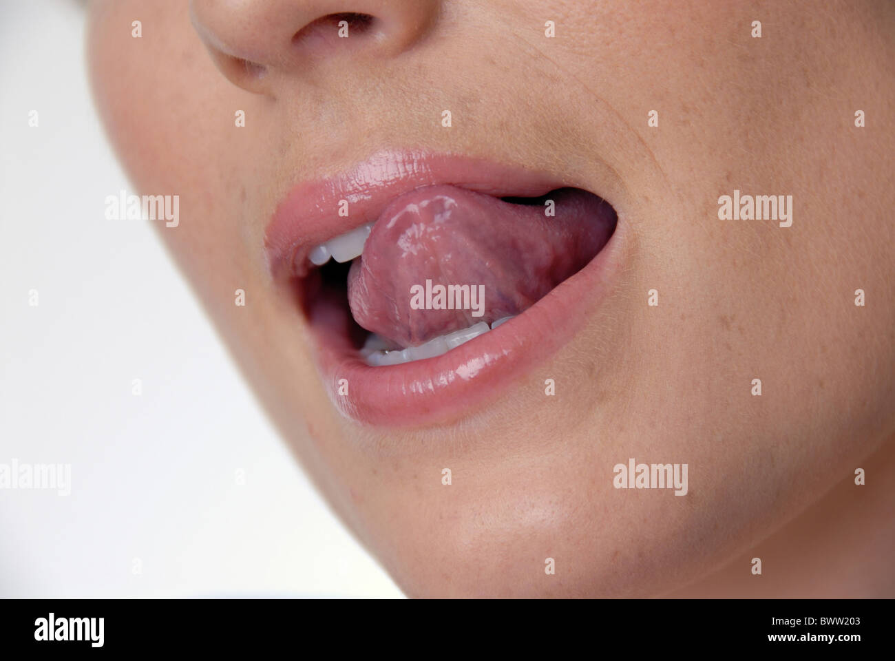 Frau junge Detail close-up, das Lipgloss Lippen lip gloss strahlend glänzende Zähne Lächeln auf den Lippen Zunge Mund Nase lickin Stockfoto
