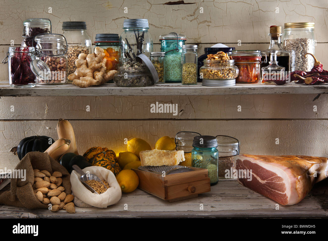 Eine Auswahl an Speisen der Speisekammer in verschiedenen Gläsern und Flaschen auf lackierten rustikale Holz Regale Stockfoto