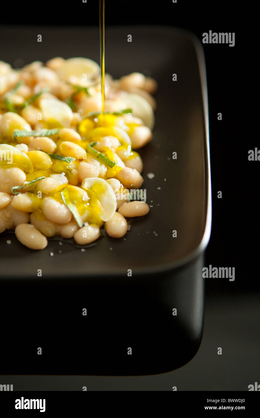 Gekochte weiße Bohnen serviert mit Knoblauch, Salbei und Extra Natives Olivenöl Stockfoto