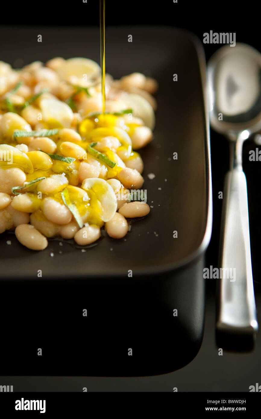 Gekochte weiße Bohnen serviert mit Knoblauch, Salbei und Extra Natives Olivenöl Stockfoto