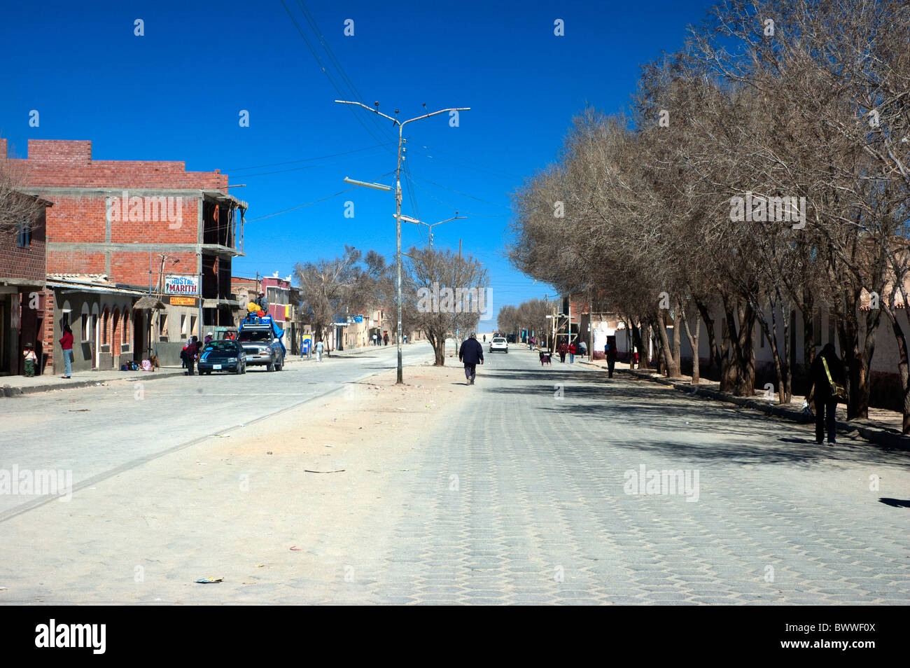 Eine sehr karge aussehende wichtigsten Straßenszene, vor blauem Himmel, Avenue Potosi, Uyuni, Bolivien. Stockfoto