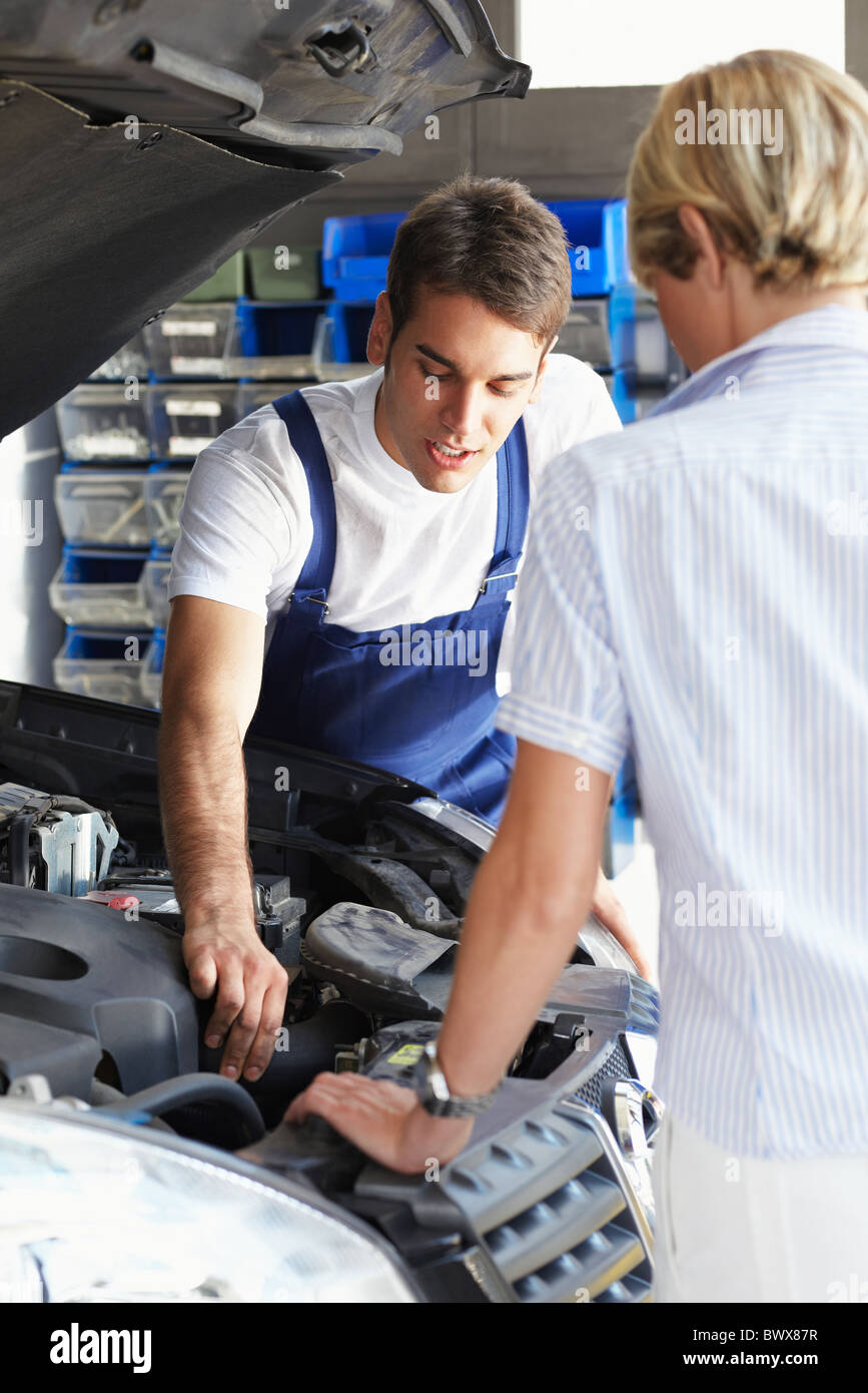 Mechaniker mit weiblichen Kunden in Autowerkstatt zu reden. Stockfoto