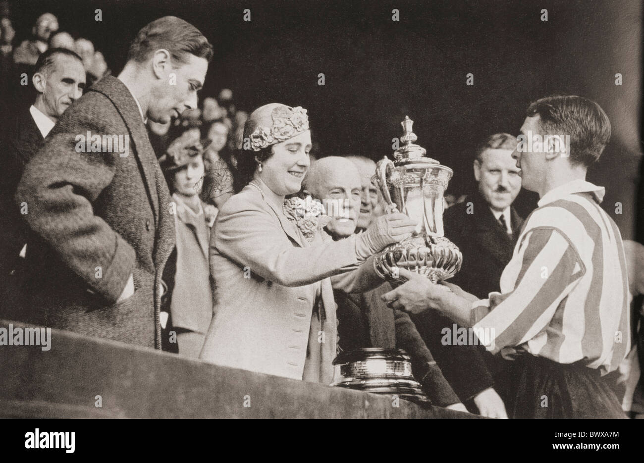König George VI und Königin Elizabeth präsentiert den Pokal Raich Carter, der Sunderland-Kapitän nach seinem Sieg des Teams im Wembley-Stadion Stockfoto