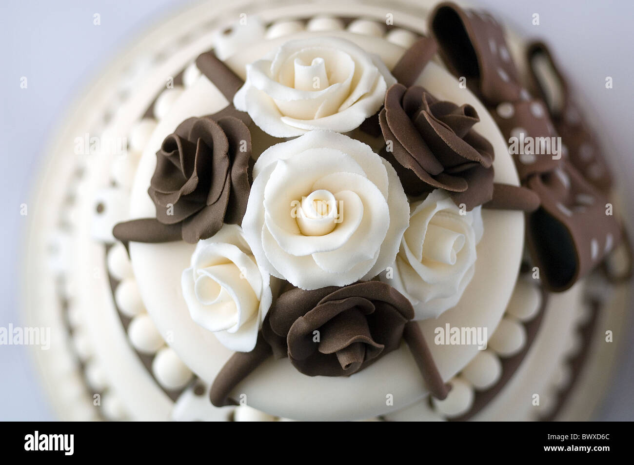 Ein braun und Creme iced Feier Kuchen mit Rosen und Schleifen Stockfoto