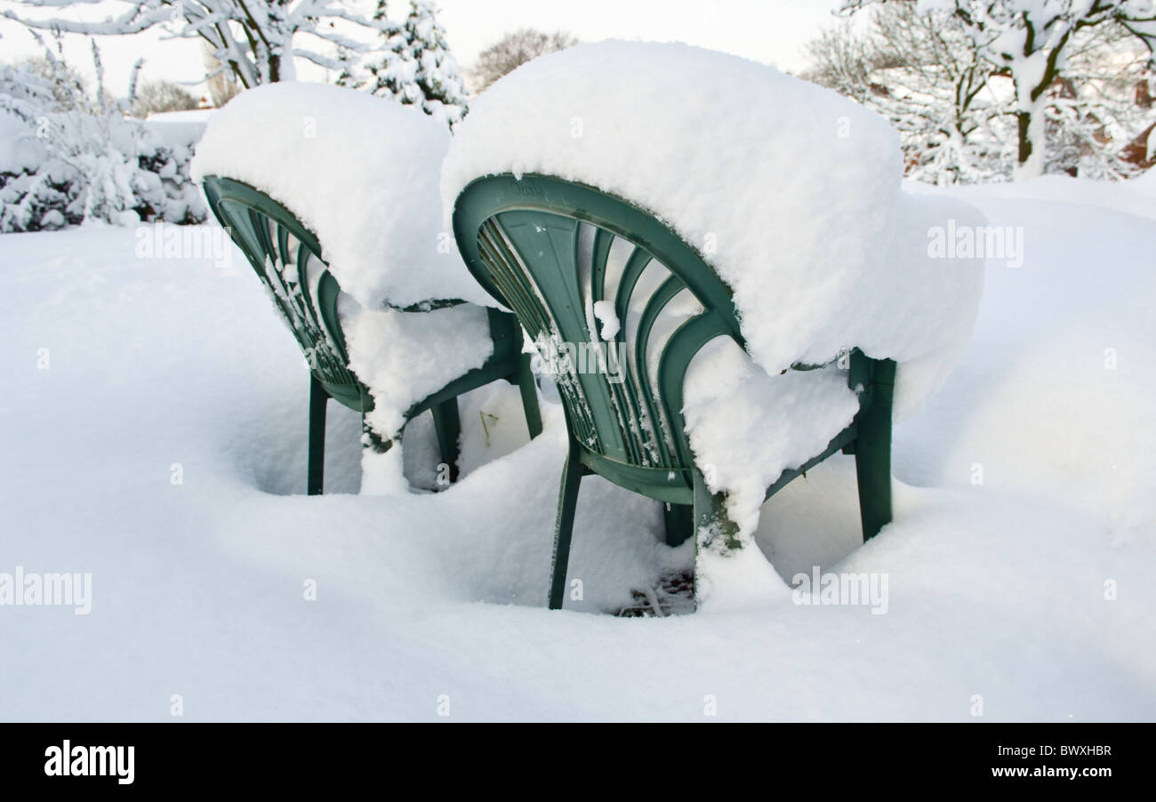 Zwei grüne Kunststoff Gartenstühle in tiefem Schnee bedeckt. Stockfoto