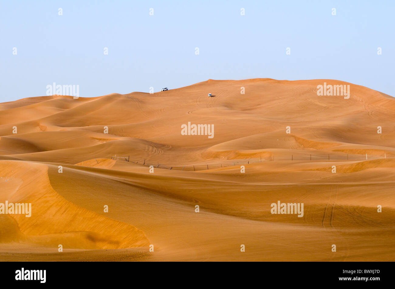 Zwei Fahrzeuge an der Spitze einer Sanddüne in Dubai mit dem Geländewagen Stockfoto