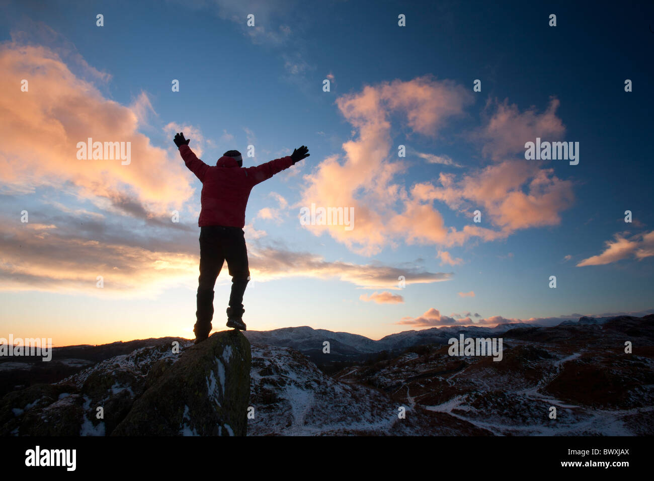 Ein Bergsteiger auf Todd Crag Gipfel im Lake District, Großbritannien, in der Dämmerung. Stockfoto