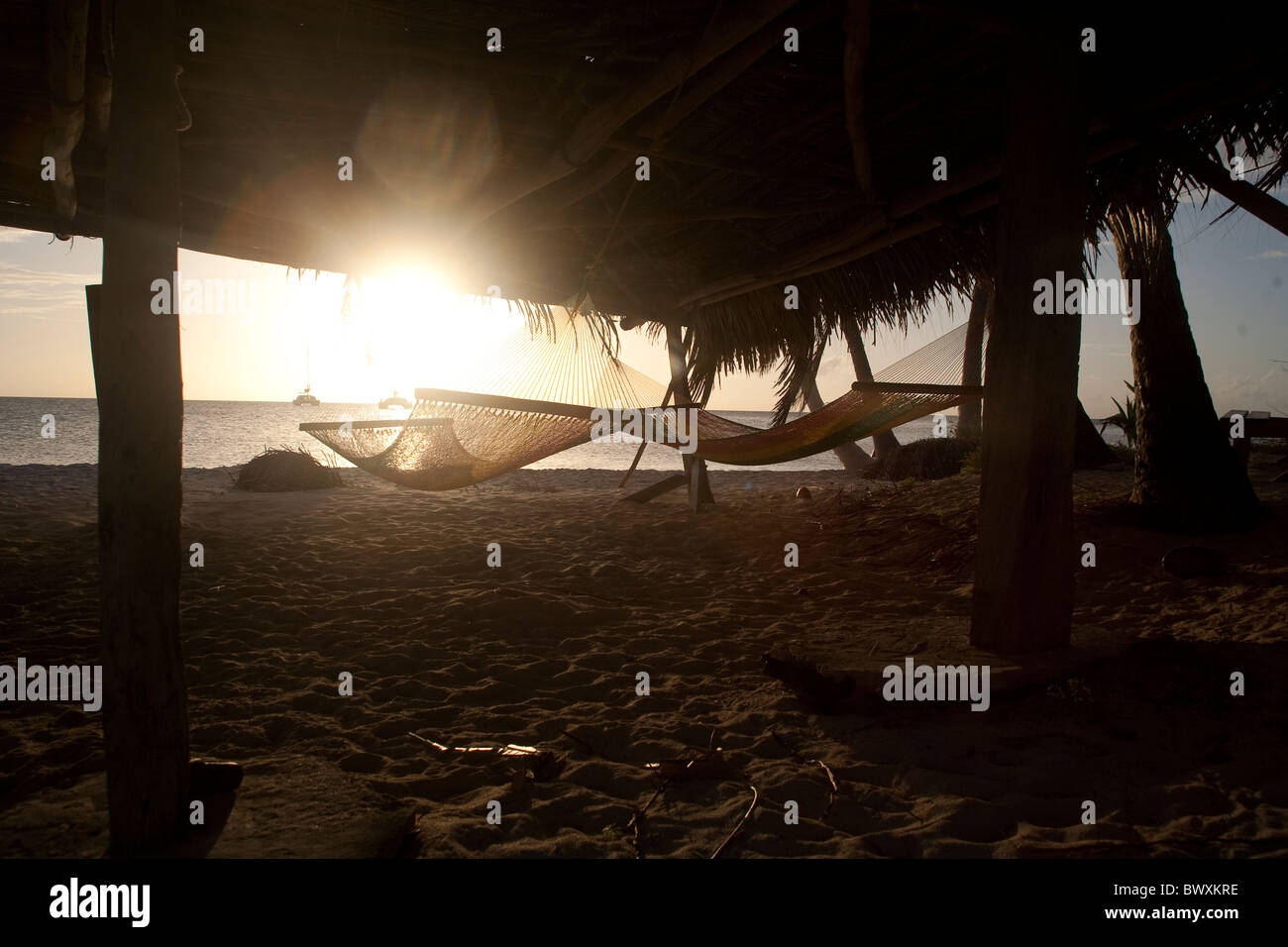 Hängematten auf tropischen Insel unter strohgedeckte Hütte am Strand Stockfoto