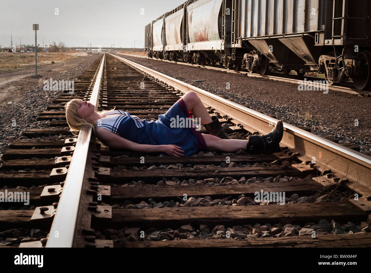 Jungfrau in Nöten legt auf Eisenbahnschienen im amerikanischen Westen Stockfoto