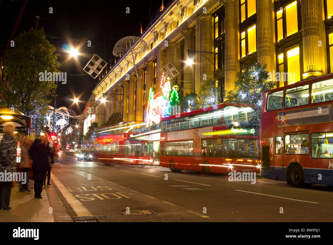 Oxford Street Weihnachtsbeleuchtung in der Nacht zeigen, Selfridges und atypische roten Londoner Busse Stockfoto