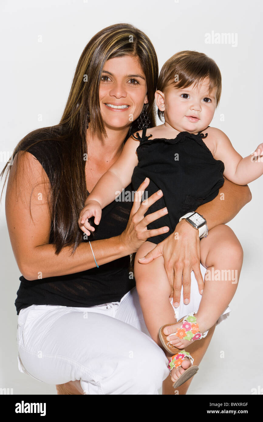 Mutter mit Babymädchen (12-14 Monate) auf Schoß, Lächeln, Porträt, Aufnahme studio Stockfoto