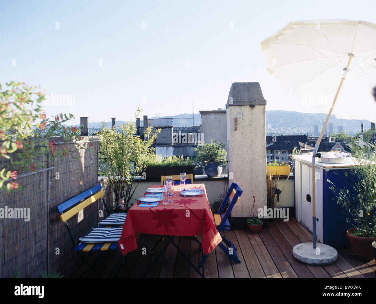 Leben Dach überdeckte Terrasse Haus Hause Holzboden Pflanzen Sonnenschirm Terrasse Tisch Schreibtisch Tischdecke Merlon Stockfoto