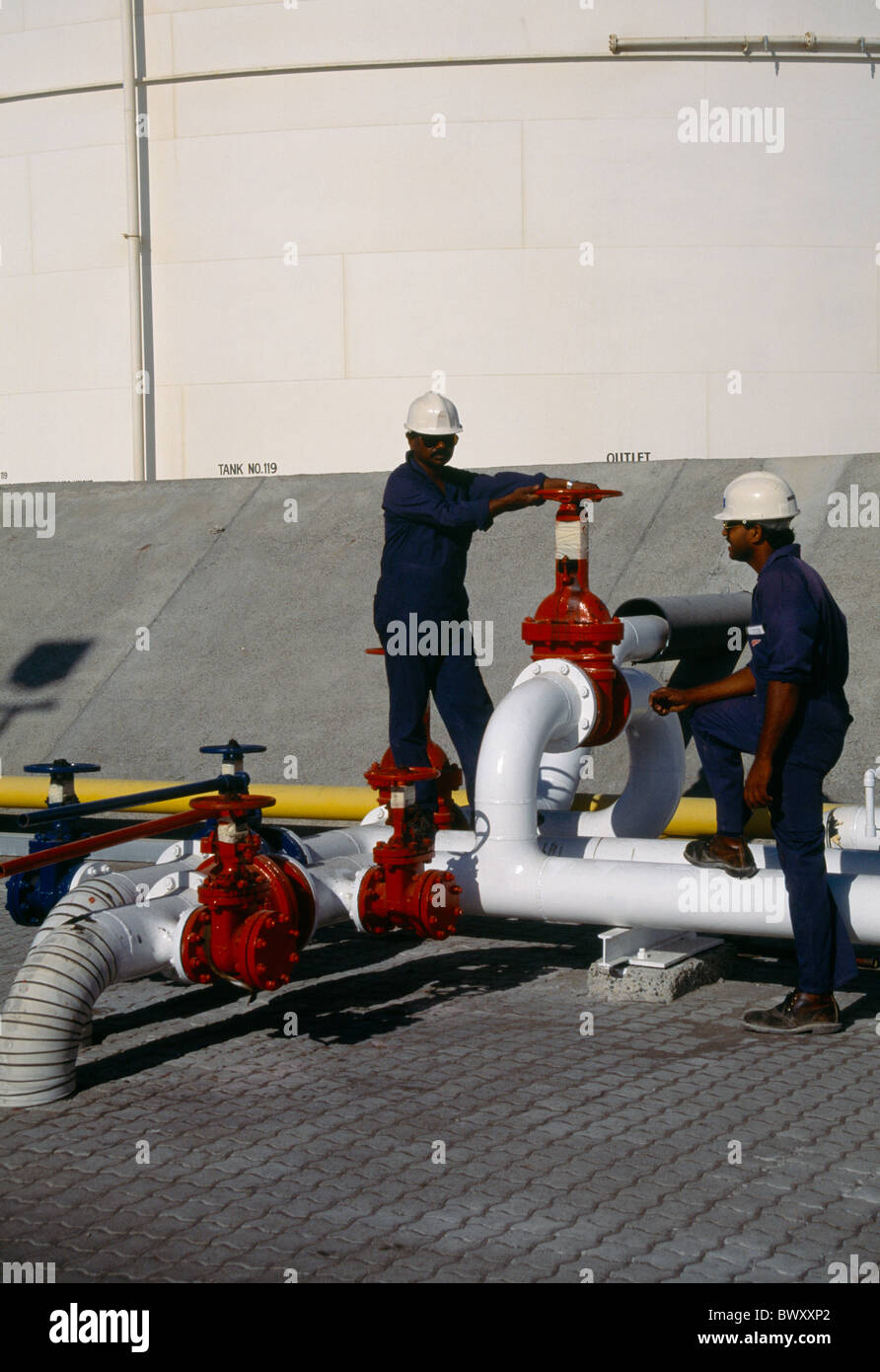Dubai Vereinigte Arabische Emirate - Oil Terminal Rohre Absperrventil - Gastarbeiter Männer In harte Hüte Lagertank Stockfoto