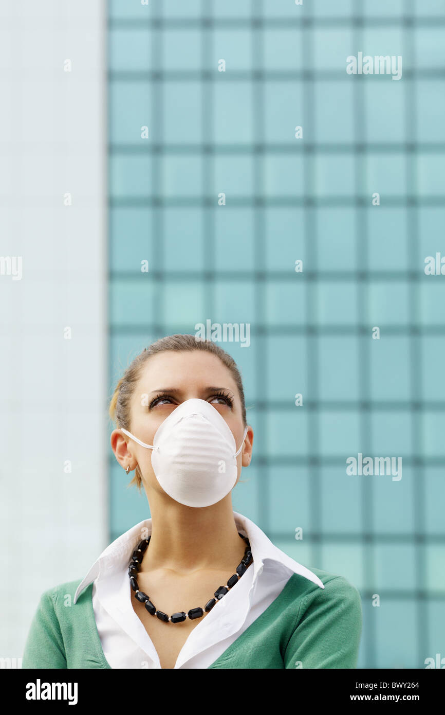 Frau stehend gegen Bürogebäude und Schutzmaske tragen. Textfreiraum Stockfoto