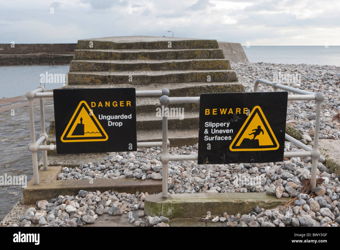 Warnschilder an den Stufen führen auf den Cobb Lyme Regis Dorset UK Stockfoto