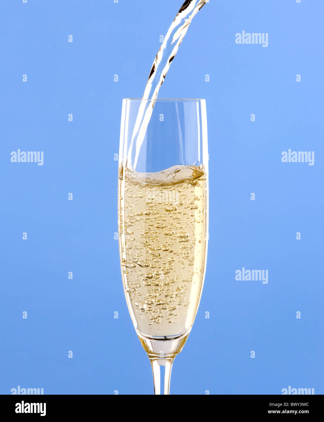 Trinken in Glas mit hellblauem Hintergrund gießen Stockfoto