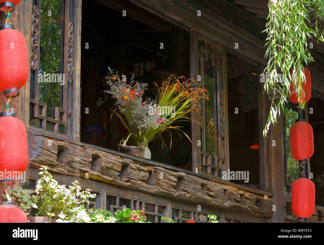 Wilde Blumen schmücken die Fenster eines traditionellen Hauses in Lijiang, Yunnan Province, China Stockfoto