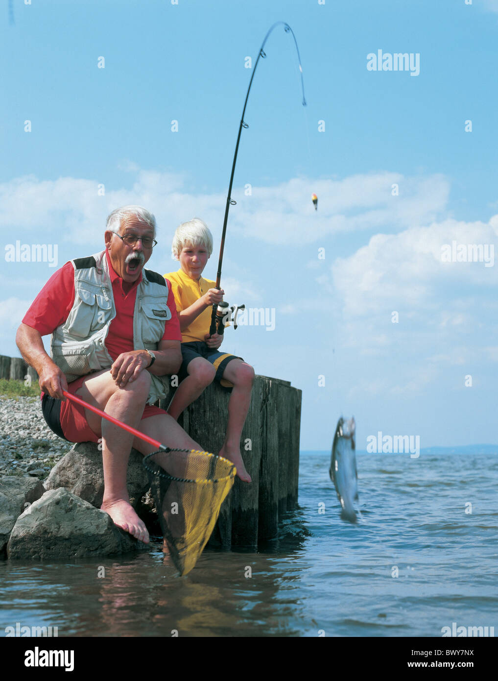 junge Kinder älterer Mann Fische fangen Fischen Fischnetz Generationen Großvater Enkel Scharnier Stab Freude Lac la Stockfoto