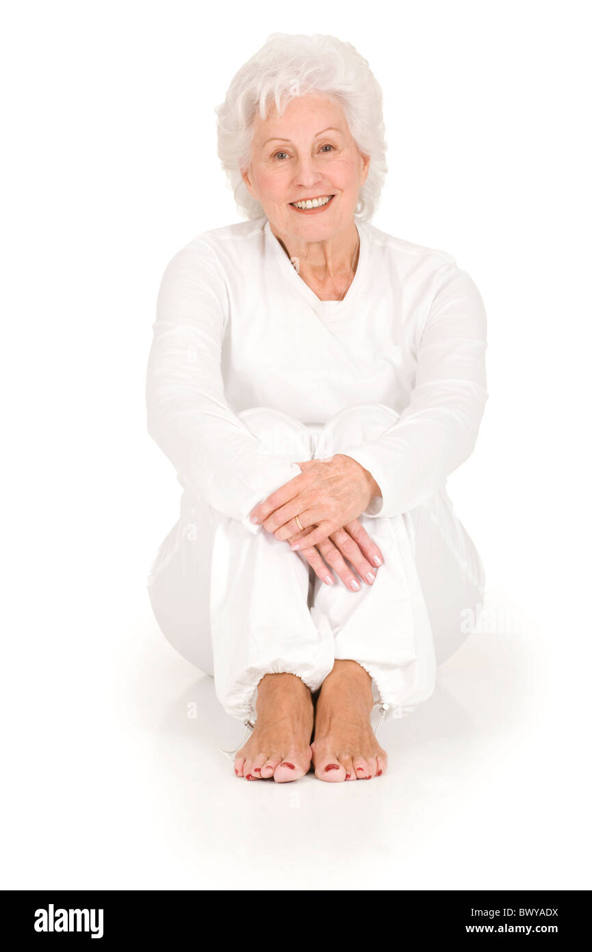 ältere Frau, die auf dem Boden sitzend Stockfoto