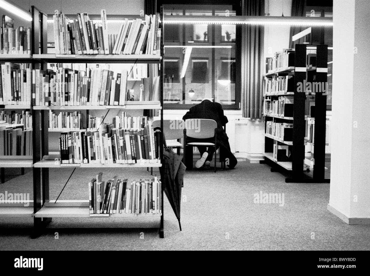 Archiv Bibliothek Bücher Buchregale innen lesen Literatur Mann Regale Regenschirm schwarz / weiß Tisch des Stockfoto