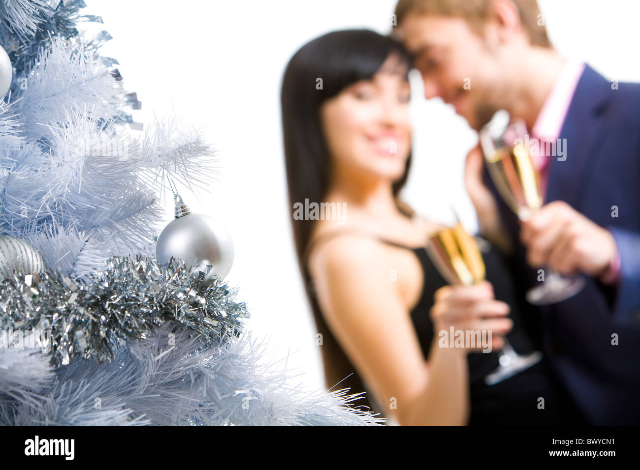 Teil des festlichen Silvester Baum geschmückt mit silbernen Girlanden und Spielzeug Kugeln auf Grund des glücklichen Paares Stockfoto
