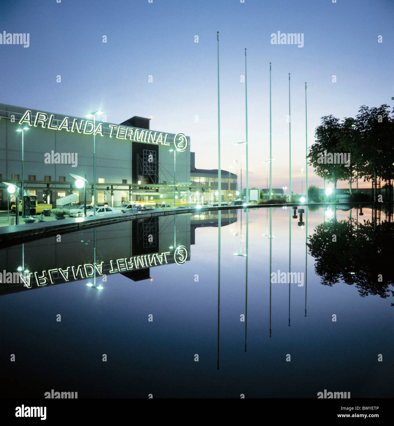 Flughafen-Architektur außerhalb Fahnenmasten maßstabsgerechte Flughafengebäude Bau moderner Nacht nachts Swe Stockfoto