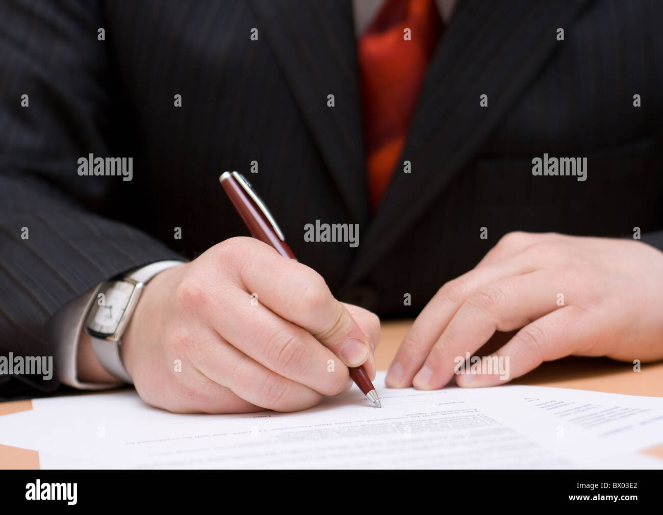 Ein Geschäftsmann, eine Papier zu unterzeichnen. Stockfoto