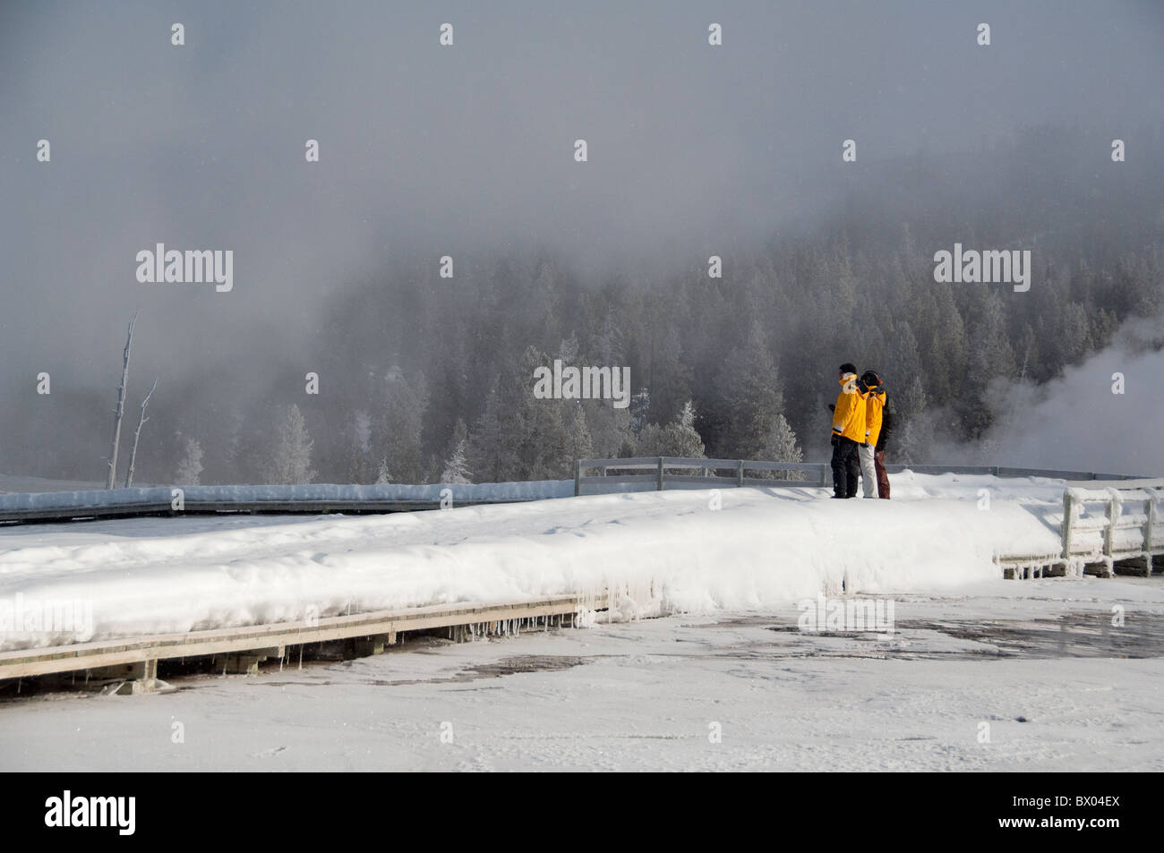 USA, Wyoming. Yellowstone-Nationalpark, Touristen auf den Old Faithful Geysir Loop Trail im Winter. Model-Release. Stockfoto