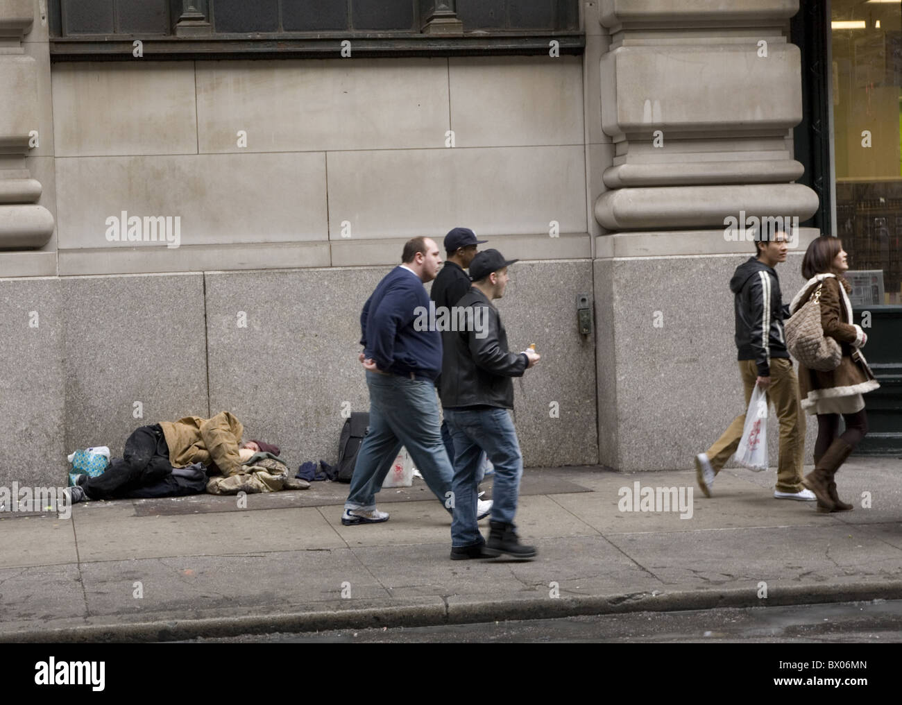 Fußgänger Fuß durch ein Obdachloser schläft auf dem Bürgersteig in New York City. Stockfoto
