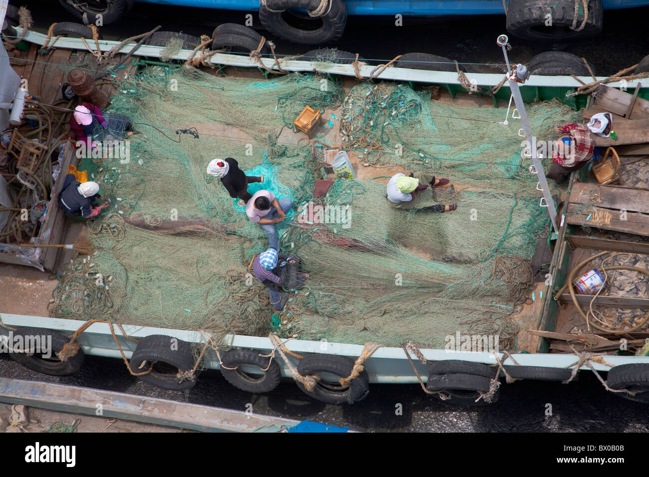 Fischer reparieren Fischnetz in einem Fischerboot, Zhoushan, Zhejiang Province, China Stockfoto