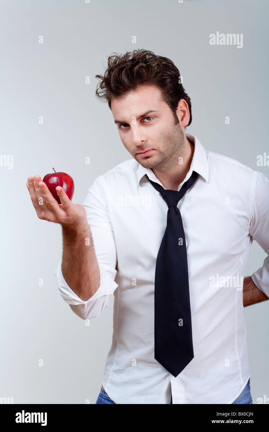 Mann in weißem Hemd und Krawatte halten Sie suchen roter Apfel - isoliert auf grau Stockfoto