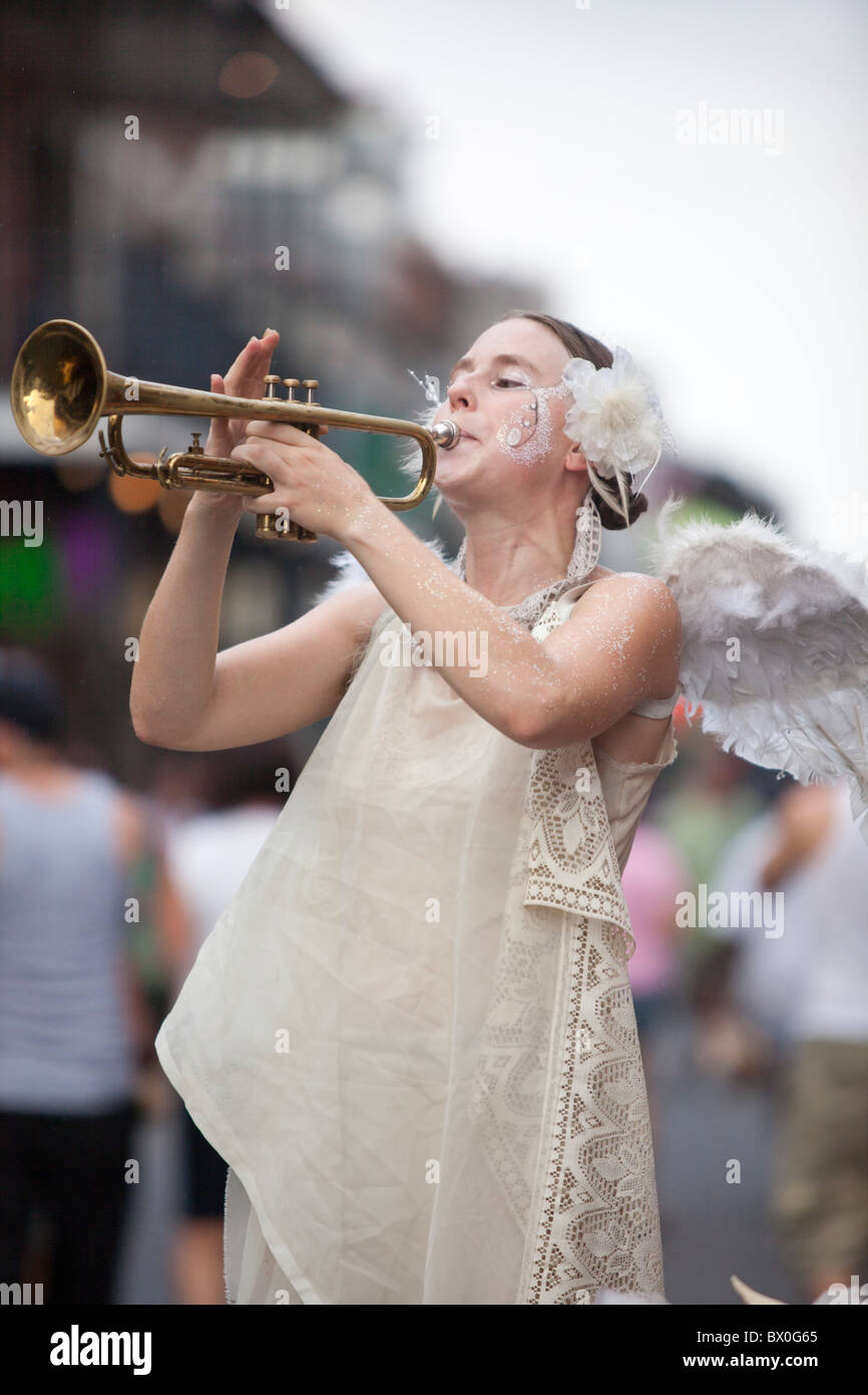 Eine Frau, gekleidet wie ein Engel spielt Trompete Tipps zur Bourbon Street im French Quarter von New Orleans, Louisiana. Stockfoto