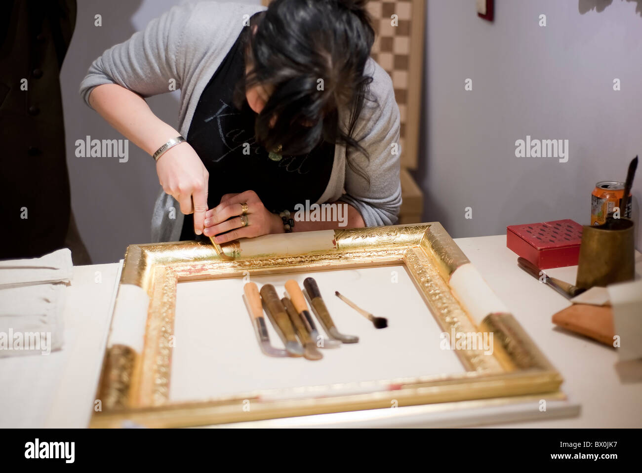 Ein junger Handwerker Vergoldung von Bilderrahmen Stockfoto