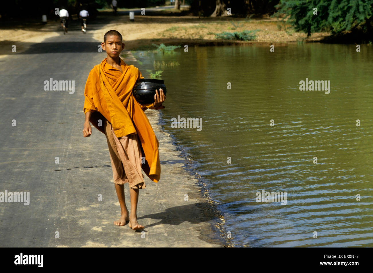 Young-buddhistischer Mönch zu Fuß entlang einer Landstraße, Bagan, Myanmar. Stockfoto