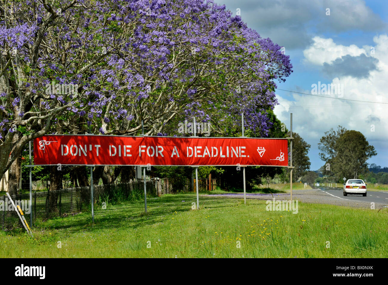 Ein am Straßenrand Sicherheitszeichen in Australien fordert Autofahrer auf den Straßen zu verlangsamen. Stockfoto