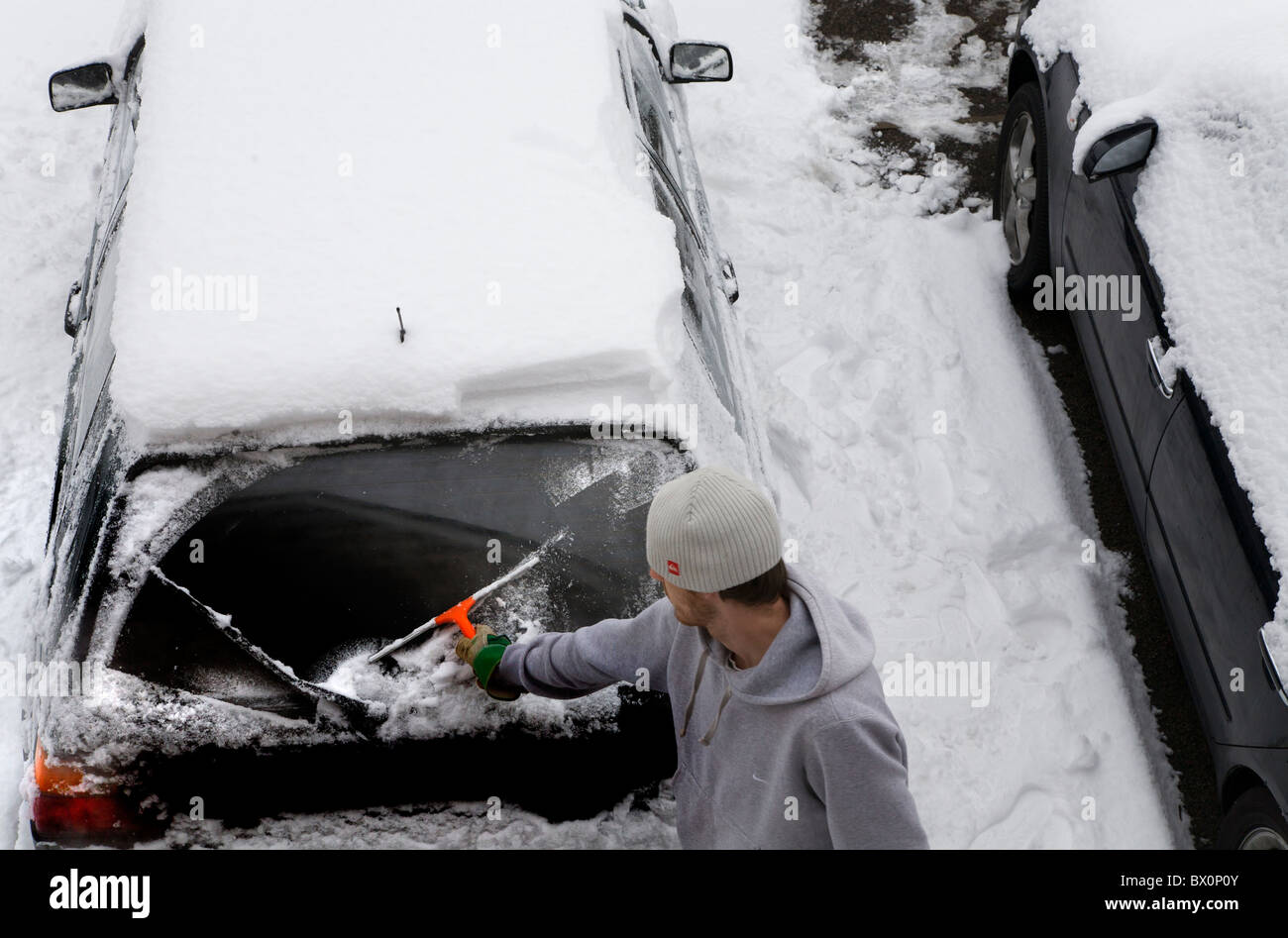 Ein junger mann reinigt schnee und eis von seinem auto -Fotos und  -Bildmaterial in hoher Auflösung – Alamy