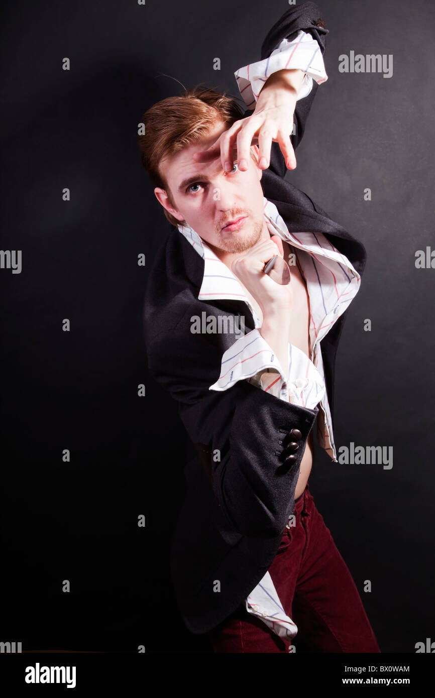junger Mann mit Messer auf schwarzem Hintergrund Stockfoto