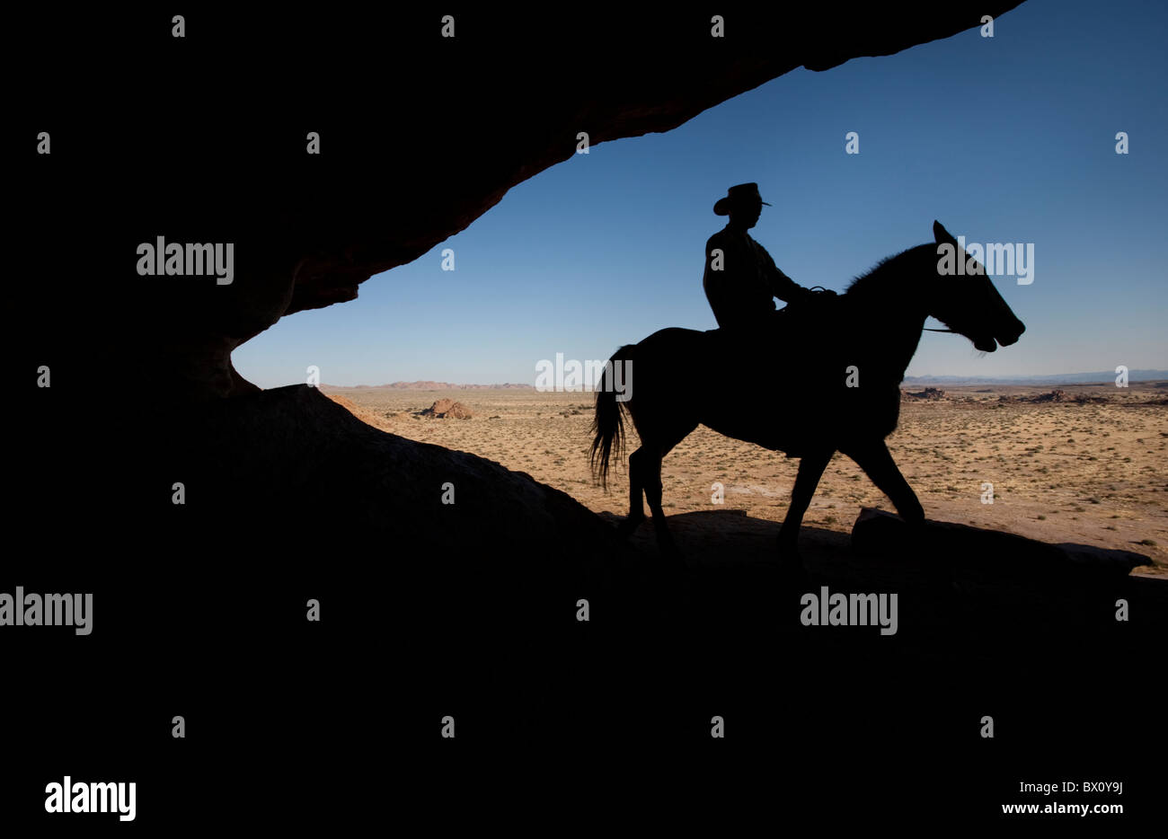 Silhouette eines Mannes reitet sein Pferd entlang eines Grates, Fish River Canyon, Namibia, Afrika. Stockfoto