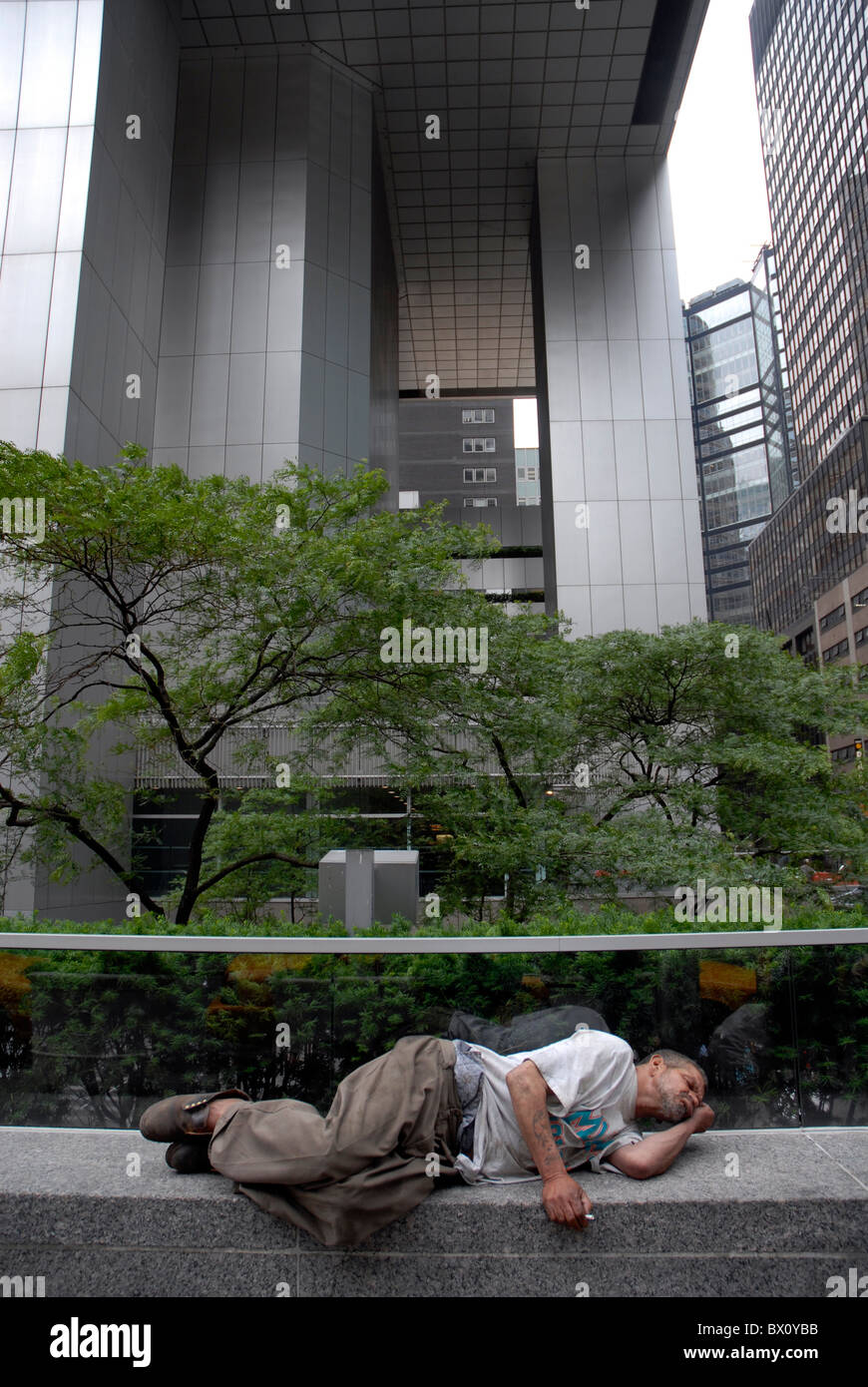 Obdachloser schläft auf einer Wand in Manhattan New York City Stockfoto