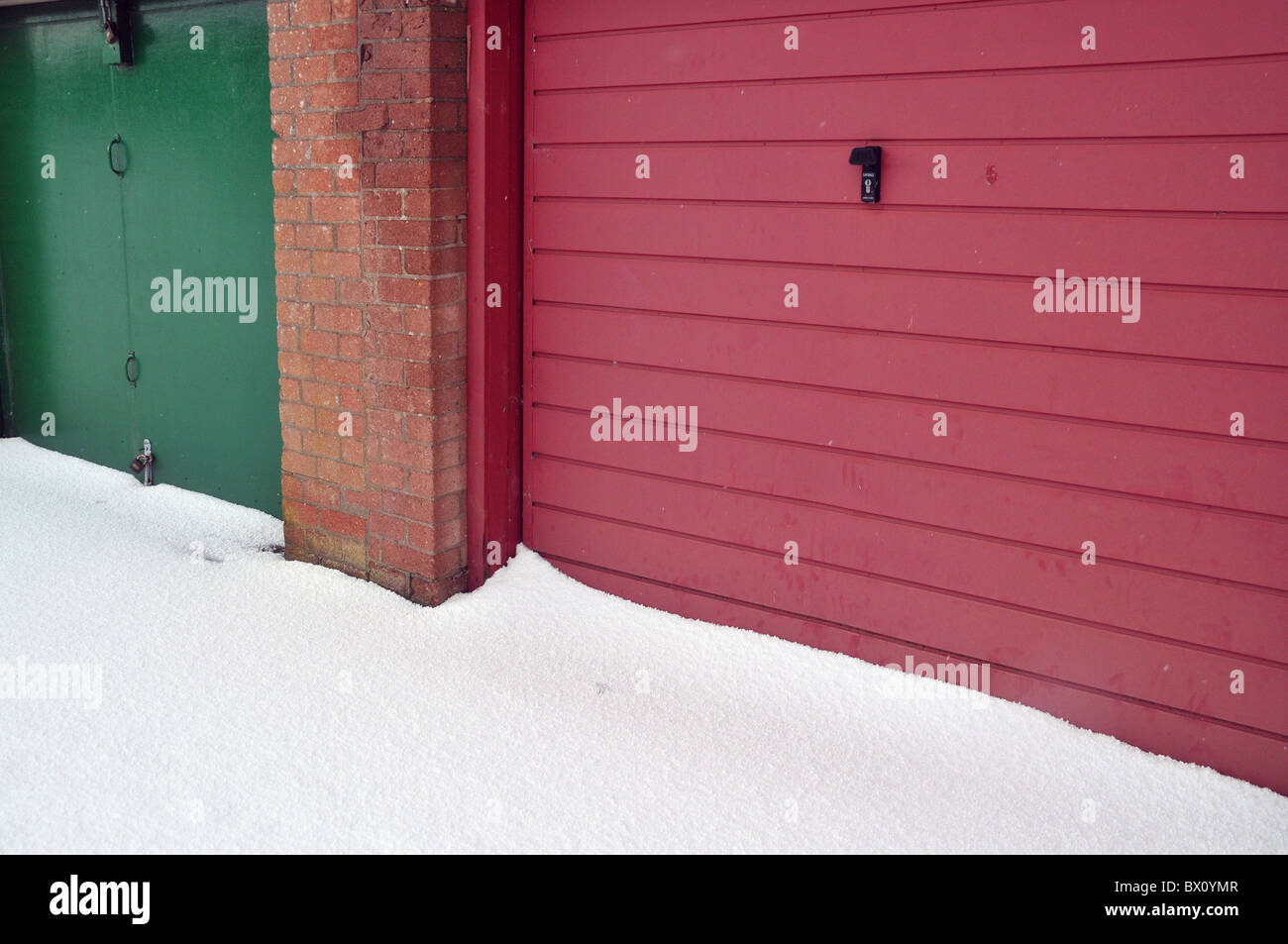 Dicken Schnee liegen gegen verschlossene grüne und rote Garagentore. Stockfoto