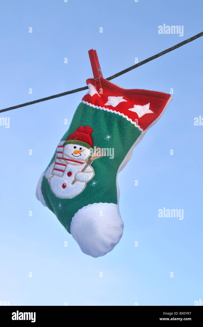 eine gefüllte Weihnachts-Strumpf an eine Wäscheleine hängen. Stockfoto