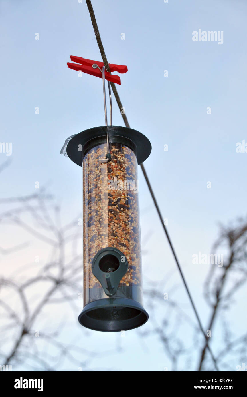 Ein Vogelhaus voller Samen hängen an einem Seil in den Wintermonaten. Stockfoto