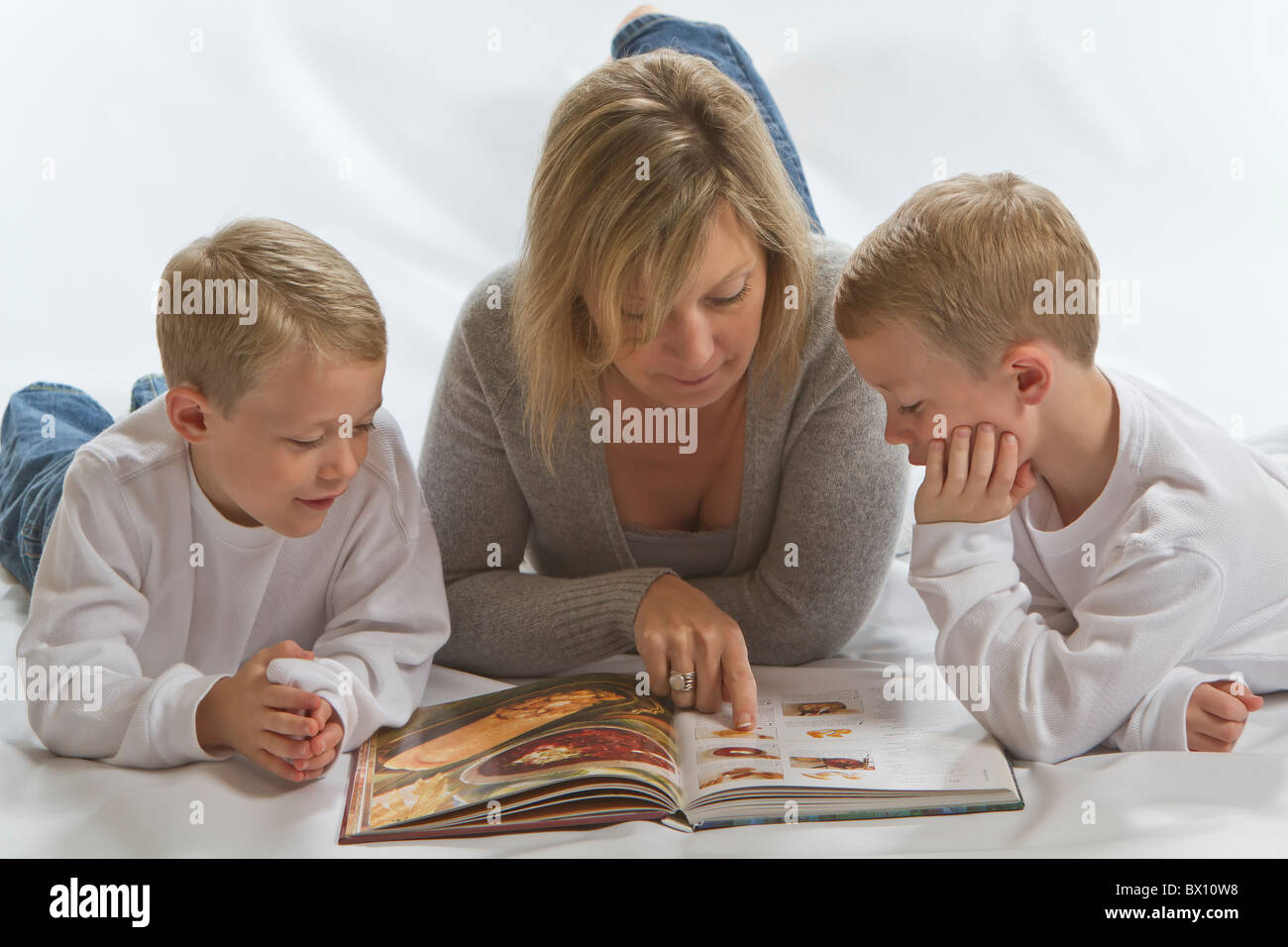 Eineiigen Zwillingen, die Hausaufgaben mit ihrer Mutter Stockfoto