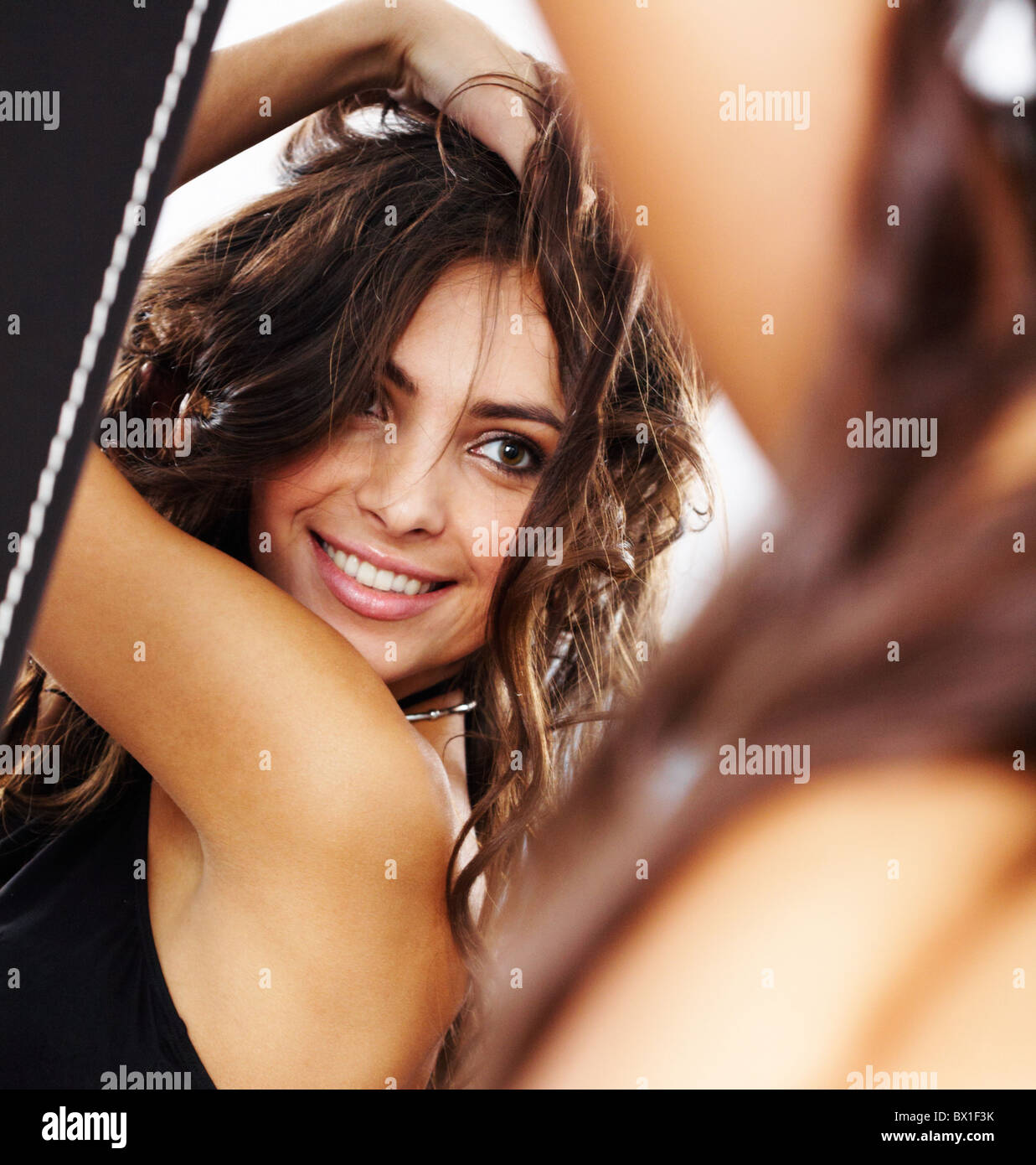 Bild der hübschen weiblichen Blick in Spiegel und amüsiert sich Stockfoto