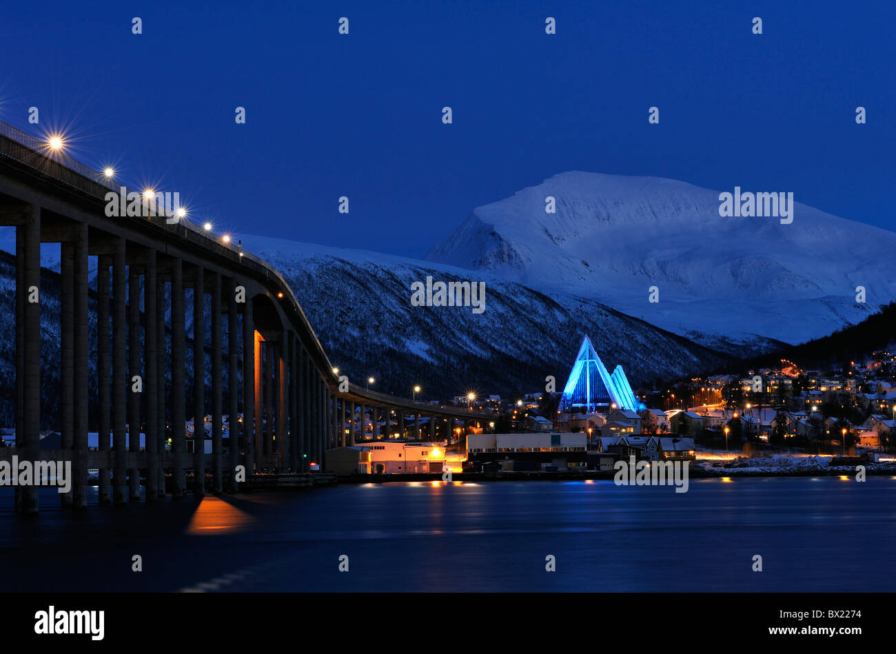 Blaues Licht auf die Eismeerkathedrale in Tromsø, Nordnorwegen. Die Brücke in Tromsø Insel auf der linken Seite. Tromsdalstinden Berg. Stockfoto