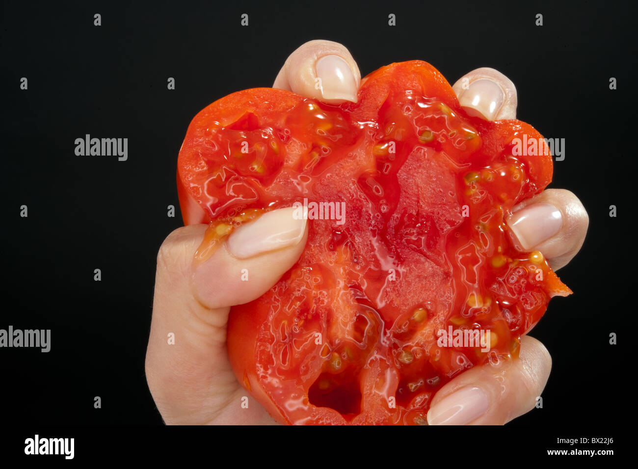 Zerkleinert, gepresst, rote Tomaten auf einem schwarzen Hintergrund. Stockfoto